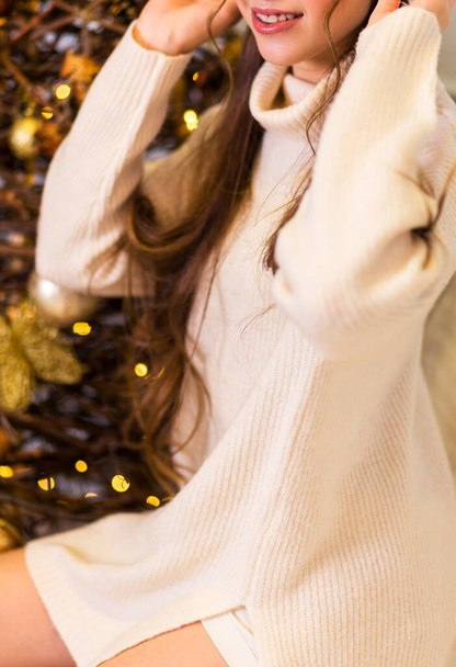 Chica posando en suéter blanco y polainas. Foto vertical - Foto, imagen