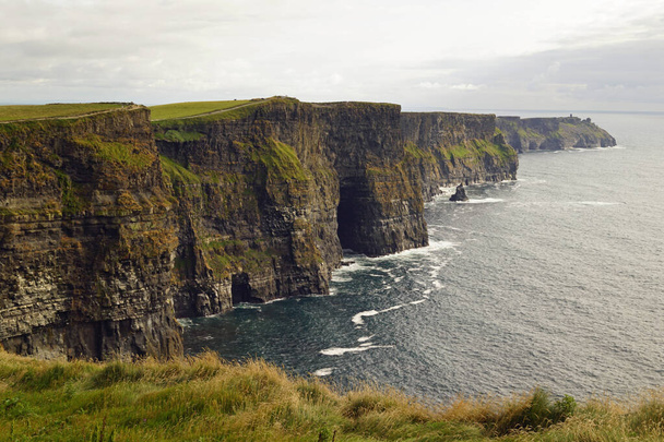Los Acantilados de Moher son los acantilados más conocidos de Irlanda. Se encuentran en la costa suroeste de la isla principal de Irlanda, en el condado de Clare, cerca de los pueblos Doolin y Liscannor.. - Foto, Imagen