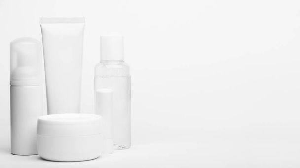 Unbranded plastic tube and containers. Set of bottles for cream, shampoo, toiletry. Flacon with dispenser for cosmetics products. Skincare and beauty concept. Mockup, copy space. Isolated on white - Φωτογραφία, εικόνα