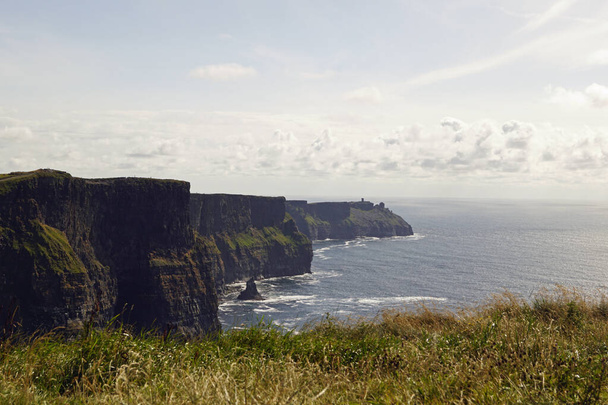Los Acantilados de Moher son los acantilados más conocidos de Irlanda. Se encuentran en la costa suroeste de la isla principal de Irlanda, en el condado de Clare, cerca de los pueblos Doolin y Liscannor.. - Foto, Imagen