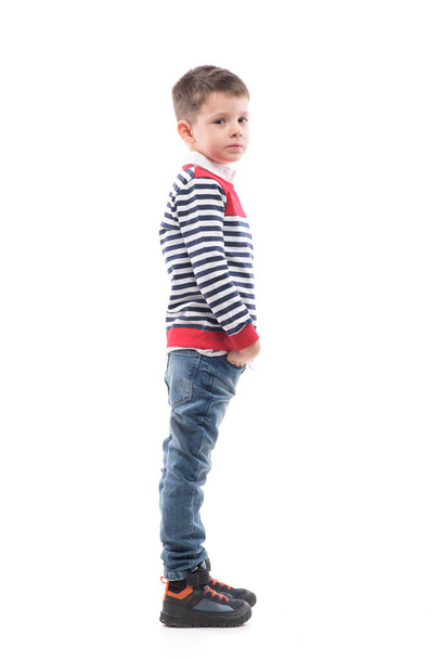 Side view of cool confident cute young preschooler kid standing with hands in pockets. Full body portrait isolated on white background.  - Fotografie, Obrázek