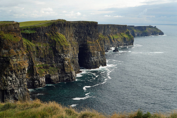 Klify Moher są najbardziej znanymi klifami w Irlandii. Znajdują się one na południowo-zachodnim wybrzeżu Irlandii głównej wyspy w hrabstwie Clare w pobliżu wsi Doolin i Liscannor. - Zdjęcie, obraz