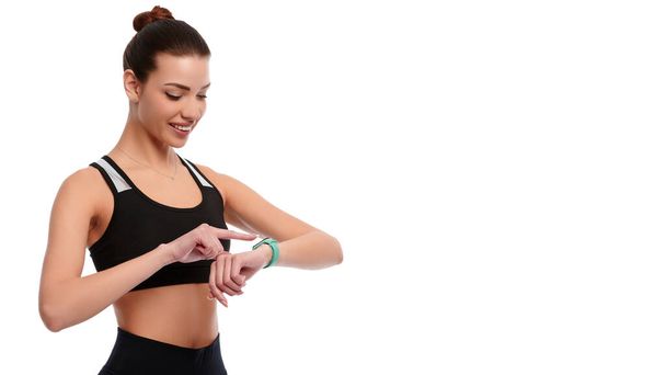 Slim forte donna caucasica in abbigliamento sportivo controllare orologi intelligenti su sfondo bianco isolato - Foto, immagini
