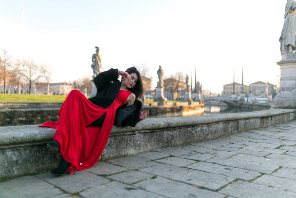 krásná dívka s dlouhými černými vlasy při západu slunce ležící na náměstí v Padově. Kvalitní fotografie - Fotografie, Obrázek