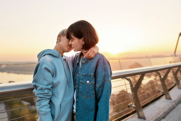 Young passionate lesbian couple kissing outdoors, Two women enjoying romantic moments together at sunrise - Foto, Imagem