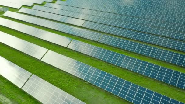 Lot wzdłuż panelu słonecznego na zielonym polu. Elektrownia słoneczna do produkcji zielonej energii. Refleksja nieba w panelu słonecznym - Materiał filmowy, wideo
