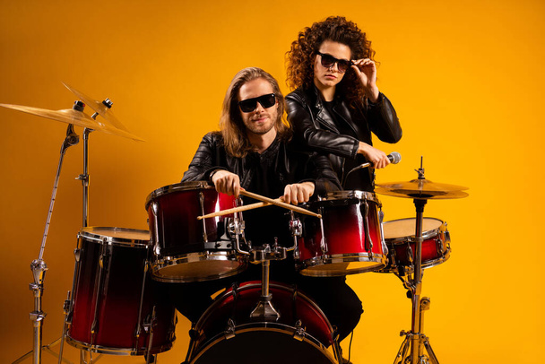 Portrait of his he her she nice attractive fashionable serious couple playing concert hobby leisure heavy metal genre rock roll gang isolated bright vivid shine vibrant yellow color background - Foto, Imagem
