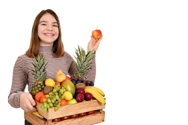 niña feliz con manzana y fruta en la caja de madera  - Foto, Imagen
