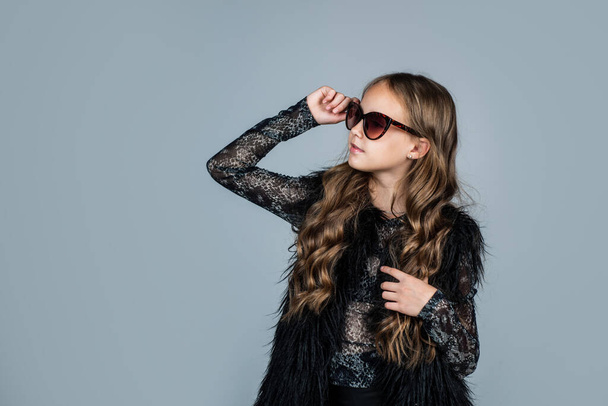 female accessory. happy teen girl in sunglasses. spring kid fashion style. child with curly hair wearing trendy clothes. concept of beauty. childhood happiness. beauty and fashion. copy space - Fotografie, Obrázek