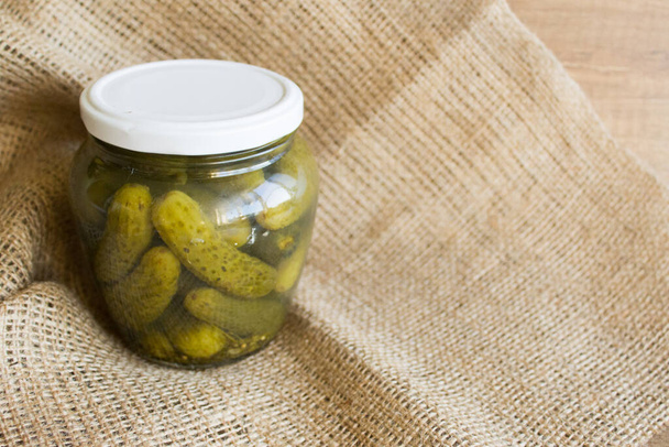 Pickled cucumbers in a glass jar. Pickled cucumbers on the table. Rustic style for Copy space - Photo, Image