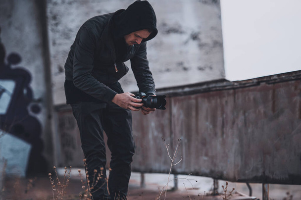 Young cameramen works on the roof of abandoned building - Photo, Image