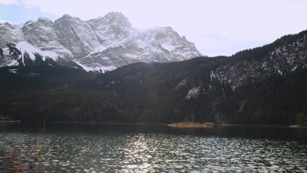  Lac de montagne réfléchissant avec de petites îles en face des montagnes enneigées dans les Alpes allemandes. Panorama d'un lac de montagne réfléchissant. - Séquence, vidéo