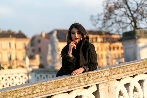 Gün batımında Padua Köprüsü 'nde uzun siyah saçlı güzel bir kız. Yüksek kalite fotoğraf - Fotoğraf, Görsel
