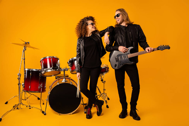 Full body photo positive girlfriend boyfriend team ready play composition song solo concert hold drumstick instrument electric guitar wear jacket sunglass isolated bright color background - 写真・画像