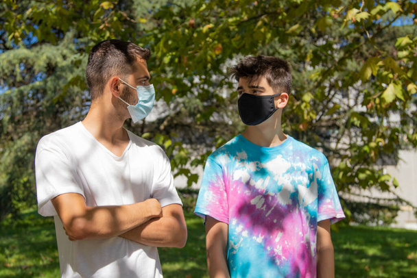 young people or students with masks talking in the street or park - Photo, Image