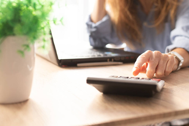 biznes kobieta ręka z kalkulator i komputer na biurku - Zdjęcie, obraz