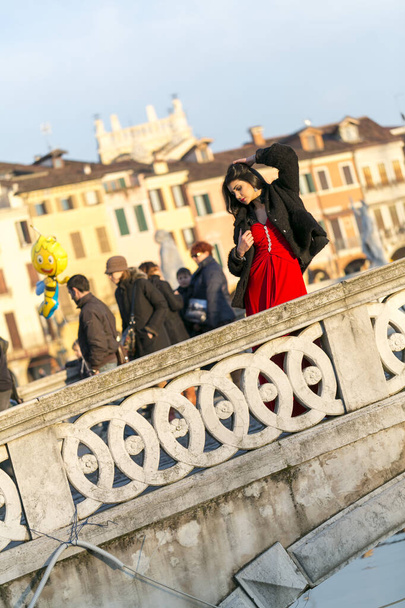 красивая девушка с длинными черными волосами на закате на мосту Падуи. Высокое качество фото - Фото, изображение