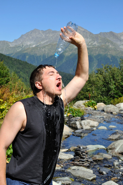 genç bir adamın kafasına plastik bir şişe su dökülen, - Fotoğraf, Görsel