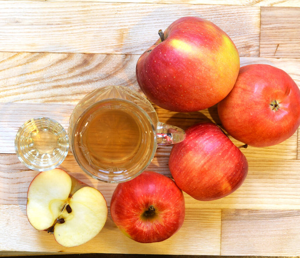 Vinaigre de cidre de pomme en bouteille en verre et pommes fraîches sur fond en bois
 - Photo, image