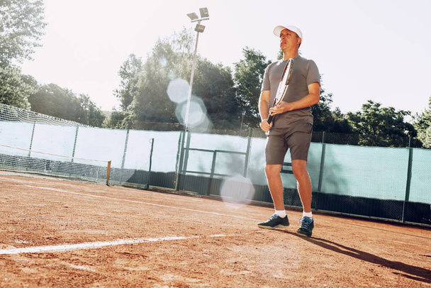 Middle-aged man playing tennis on outdoor tennis filed - Фото, зображення