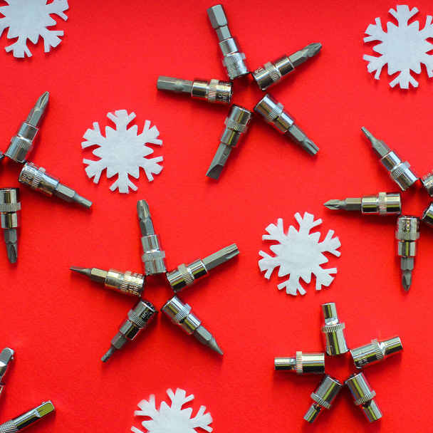 Flocons de neige de Noël à partir d'outils de construction sur un fond rouge. Le concept du nouvel an pour un service de voiture. Empilage plat, espace de copie, vue de dessus - Photo, image