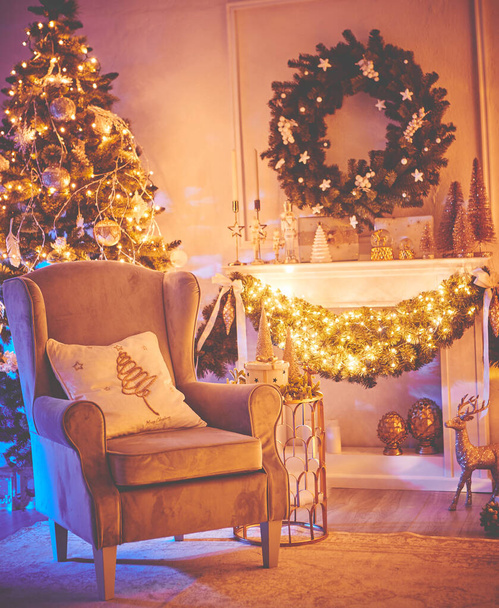 Christmas interior concept. With fireplace, armchair, pine tree, wrapped gifts, lights - Фото, изображение