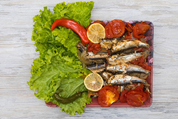 Fisch geschmort in Gemüse mit Zitrone. Kulinarischer Hintergrund mit selektivem Fokus und verschwommenem Hintergrund. - Foto, Bild
