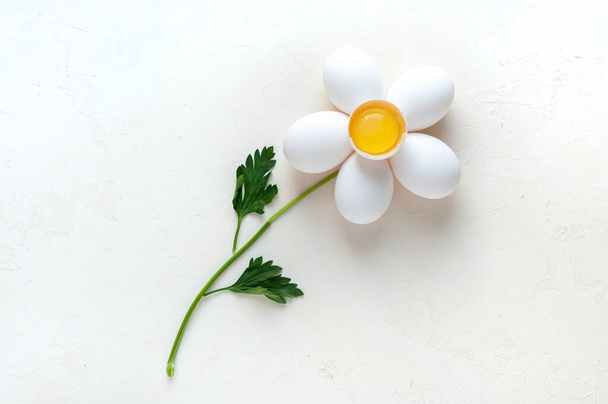 Creative concept photo of a flower made of eggs and parsley on white background - Photo, image