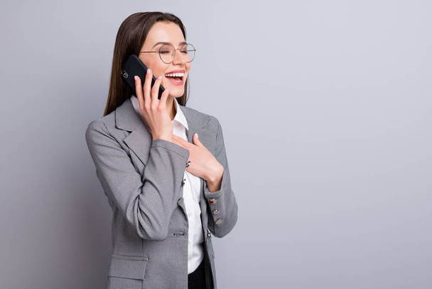 Photo of attractive business lady confident manager worker hold telephone hands talk partner laughing good jokes wear specs shirt plaid blazer isolated grey color background - Fotó, kép