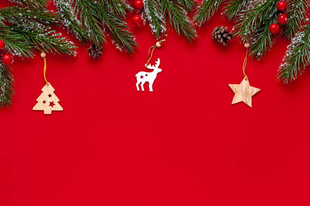 Fenyő ágak, fa karácsonyi játékok piros hátterű.Karácsonyi vagy újévi háttér szöveges elhelyezés - Fotó, kép