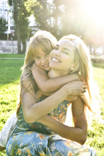 Kleine dochter knuffelt haar moeder - Foto, afbeelding