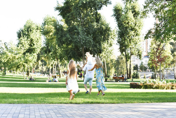 Семья играет в парке со своей собакой - Фото, изображение