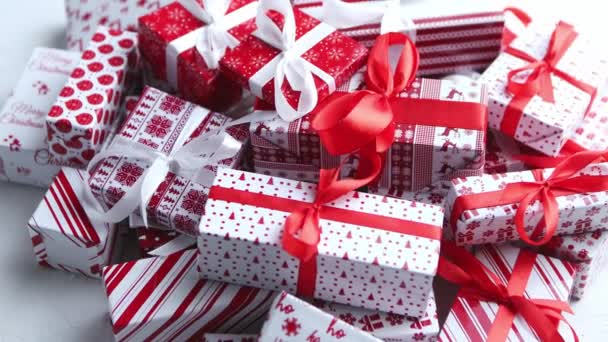 Kerstconcept. Close-up op feestelijk papier verpakt geschenken met lint - Video