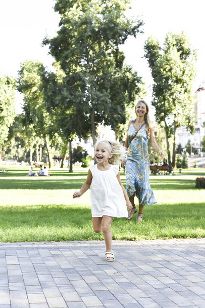 Äiti ja tytär juoksevat nurmikolla. - Valokuva, kuva
