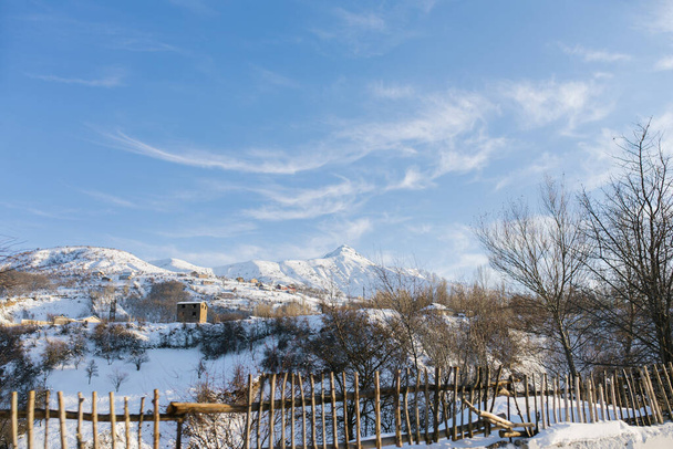 Прекрасная снежная зима в горах Узбекистана, в деревне Чимган. Открытие горного ландшафта с дороги в Ташкент - Фото, изображение
