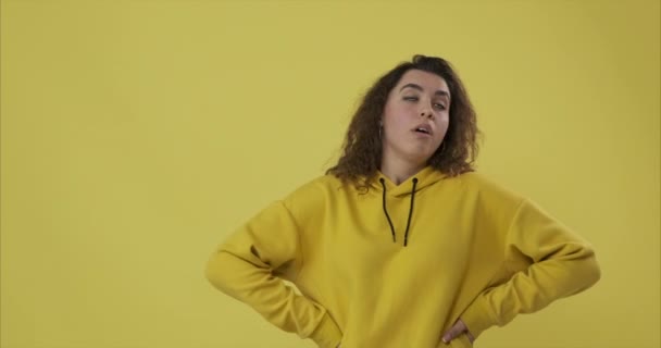 Niecierpliwa i znudzona kobieta na żółtym tle - Materiał filmowy, wideo