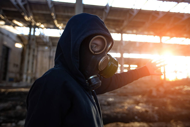 Person in gas mask in abandoned industrial building - 写真・画像
