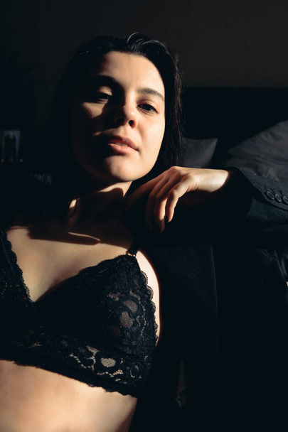 сексуальные портреты молодой женщины в куртке и бюстгальтере резкий свет - Фото, изображение