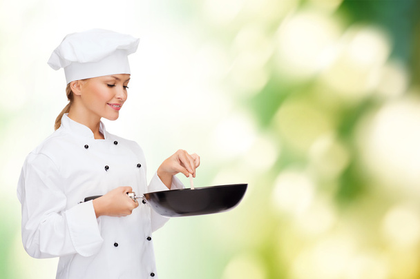 Chef féminin souriant avec casserole et cuillère
 - Photo, image