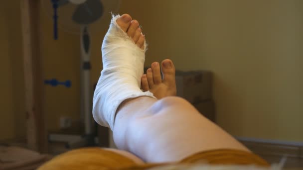male leg in a plaster cast. toes moving. Plain background, close-up. - Footage, Video