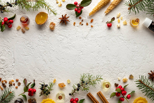 Weihnachtliche Auswahl an ätherischen Ölen mit Wintergrün, Wacholder, Weihrauch und anderen Kräutern, mit Kopierraum in der Mitte - Foto, Bild