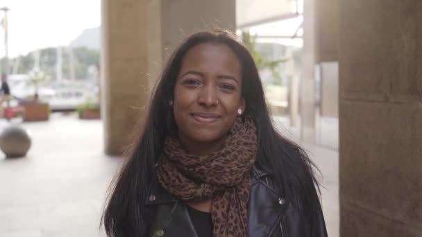 Portret van een Afro-Amerikaanse zwarte vrouw op zoek naar camera glimlachen buiten. - Video
