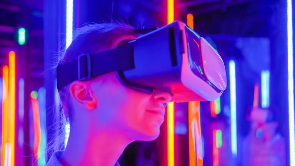 Donna che utilizza cuffie per realtà virtuale alla mostra VR interattiva: primo piano - Foto, immagini