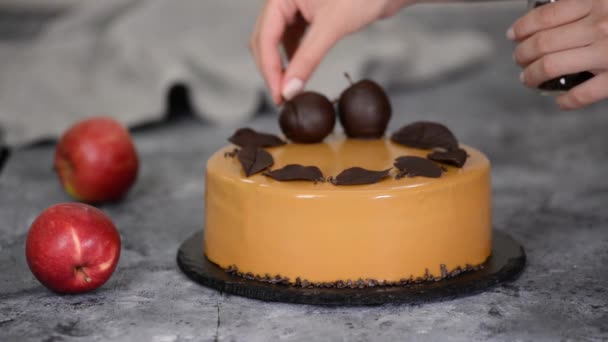 Σεφ ζαχαροπλαστικής διακόσμηση του κέικ μους με μικρά κομμάτια σοκολάτας. Ζαχαροπλαστείο σεφ διακοσμημένο σύγχρονη ευρωπαϊκή τούρτα. - Πλάνα, βίντεο