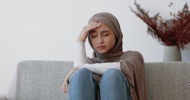 季節性うつ病。若い悲しいイスラム教徒の女性は気分の変動に苦しみ、人生の問題について考え、家に座って - 映像、動画