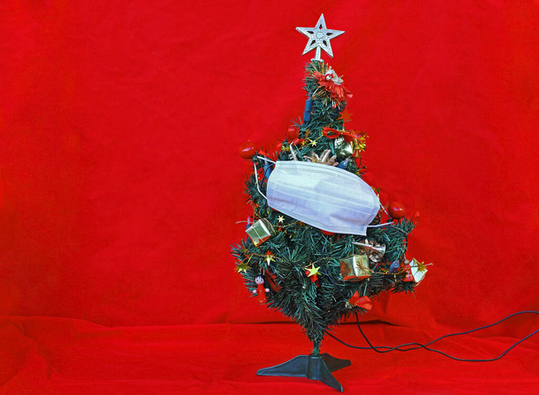 Corona ve Christmas. Noel ağacında koruyucu bir maske  - Fotoğraf, Görsel