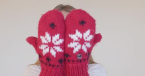 Όμορφη κοπέλα στα χειμωνιάτικα γάντια που φτιάχνει γκριμάτσες. - Πλάνα, βίντεο