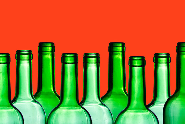 Reihe leerer Flaschen auf rotem Hintergrund - Foto, Bild
