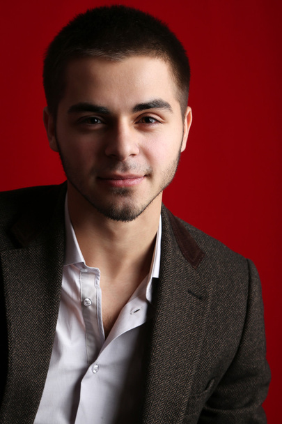 Handsome young on red background - Photo, image