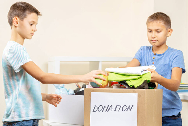 Crianças voluntárias classificando brinquedos, roupas, livros, bens de doação em doar caixas de caridade - Foto, Imagem